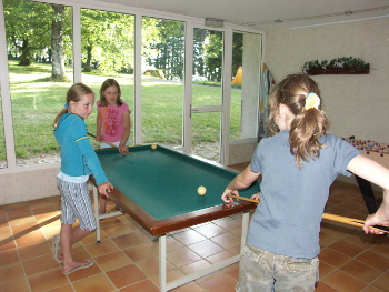 Salle de détente avec baby foot, billard, jeux de société et bibliothèque.